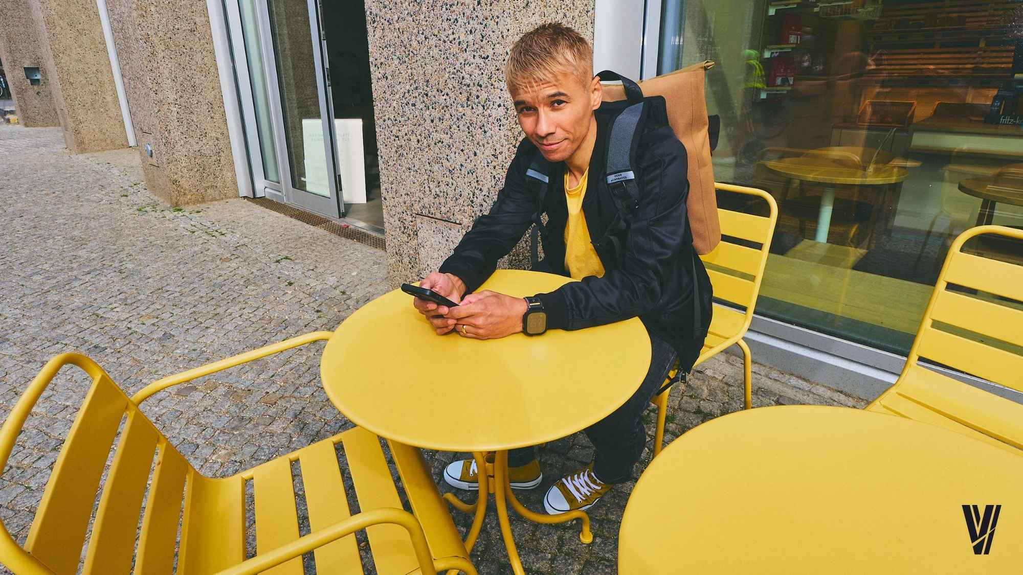 Ben Harmanus in einem Berliner Café an einem gelben Tisch. Foto: Alexander Schneider